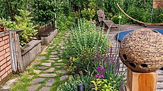 Cesta podél bazénu, která jen tak p�íjemn� únosn� zar�stá travou.