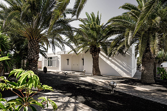 Velkorysá vila je obklopená zahradou se vzrostlými palmami. 