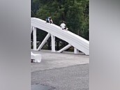Návtvníci pindlu lezou na oblouky Bílého mostu