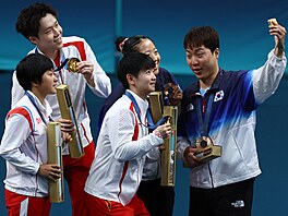 Jihokorejský stolní tenista Lim �ong-hun po�izuje selfie se soupe�i v turnaji...