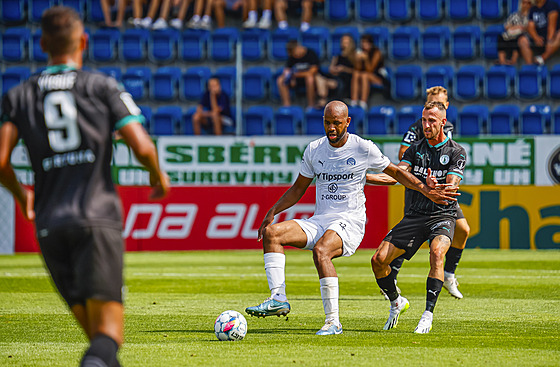 Úto�ník Slovácka Rigino Cicilia zpracovává mí� p�ed obráncem Bohemians Mat�jem...