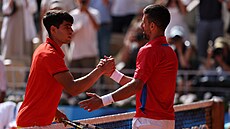 Novak Djokovič a Carlos Alcaraz si podávají ruce po vzájemném utkání.