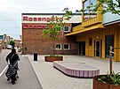 Zahalená �ena s ko�árkem prochází kolem nákupního centra ve �tvrti...