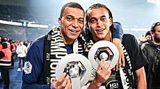 Kylian Mbappé se svým mladím bratrem Ethanem drí trofeje pro vítze...
