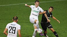 Úto�ník Filip Vecheta z Karviné si v souboji kryje balon p�ed bránícím Luká�em...