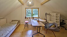 Jednodu�e za�ízená pracovna v podkroví. P�evládající masivní d�evo a sv�tlá...