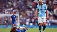 Obránce Chelsea Marc Cucurella le�í  v k�e�ích na trávníku. Vedle n�j stojící...