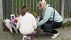 Lidé nosí kv�tiny na místo po�áru v anglickém Bradfordu. (21. srpna 2024)