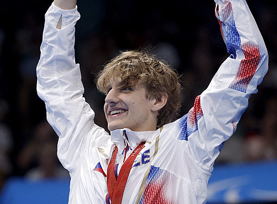 David Kratochvíl slaví na pódiu stíbrnou medaili z disciplíny 100 m znak.