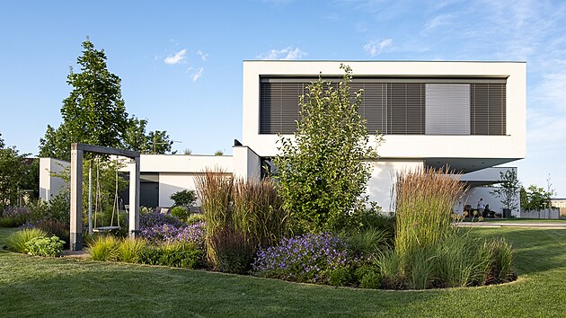 Intenzivn� sekan� tr�vn�k kolem domu je nov� naru�en n�kolika ostrovy zelen�, co� do zahrady vneslo lidsk� m���tko a p�irozen� ji to propojilo s krajinou.