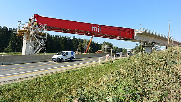 Vsuv dlnin estakdy nad silnic I/35. Zvedac hydraulick zazen (vlevo) kompenzuje prhyb ervenho vsuvnho nosu ped vsuvem na dal opru. Tzn. aby konstrukce plynuje najela na dal podpru s loiskem, mus se v zvislosti na dlce mostnho pole pizvednout a o 40 centimetr. Mostn pole nad silnic I/35 m dlku 62 metr. (5. z 2024)