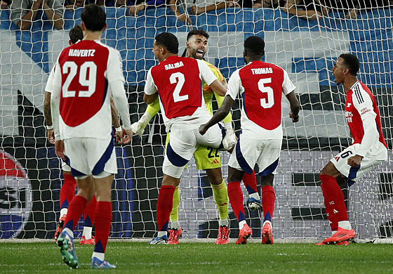 Fotbalisté Arsenalu slaví s brankáem Davidem Rayou chycenou penaltu proti...