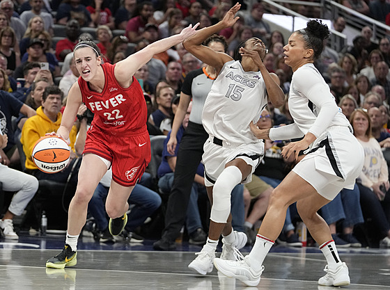 Caitlin Clarková (22) z Indiana Fever se tla�í kolem Tiffany Hayesové (15) z...