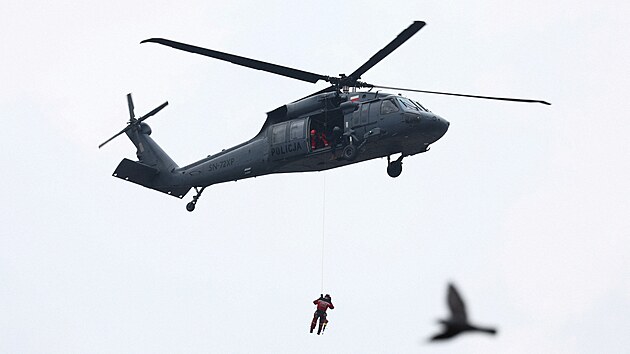 �len z�chrann�ho t�mu vis� z vrtuln�ku Black Hawk b�hem odstra�ov�n� n�sledk� povodn� ve m�st� Latek Zdroj v Polsku (15. z��� 2024)