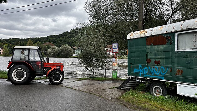 Traktor odv od Vltavy maringotky pvoz, aby nesniovaly prtok vody v koryt a na bezch. (14. z 2024)