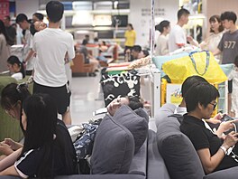 Zákazníci v obchodním dom� IKEA ve m�st� Chang-�ou odpo�ívají ve vystavených...