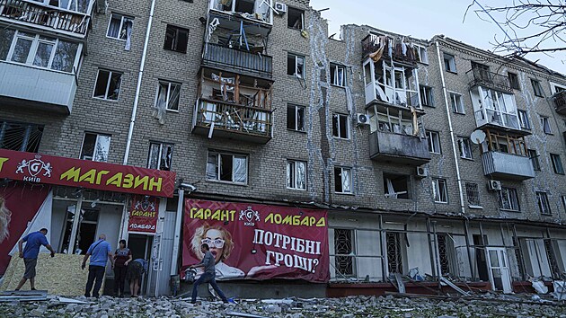 Lid� odkl�zej� trosky p�ed obytnou budovou, kter� byla siln� po�kozena po rusk�m n�letu v Kramatorsku v Don�ck� oblasti. (25. z��� 2024)