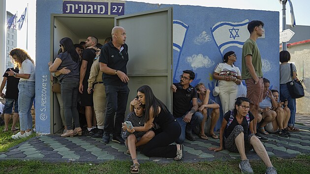 Izraelci ve m�st� Naharija u krytu, kdy� sir�na varuje p�ed raketami vyp�len�mi z Libanonu. (19. z��� 2024)