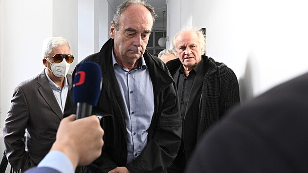 �len kapely Pra�sk� v�b�r Michael Koc�b (vpravo) a dva b�val� p��slu�n�ci St�tn� bezpe�nosti u Obvodn�ho soudu pro Prahu 1 p�ed za��tkem  jedn�n� o  dohod� o vin� a trestu. (23. z��� 2024)