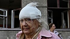 Zran�ná �ena se dívá na sv�j obytný d�m zasa�ený ruským náletem v Záporo�í na...