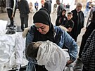 �ena dr�í zahalené t�lo svého dít�te zabitého p�i izraelských útocích v Rafáhu....