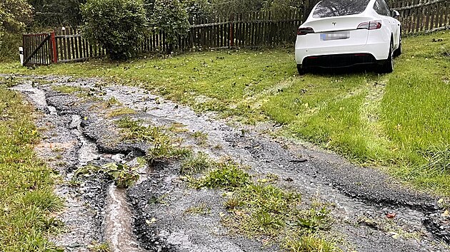 Voda prot�k� domem a venku ni�� rok starou p��jezdovou cestu.