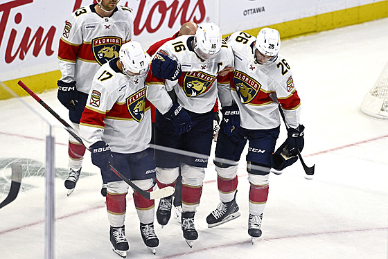 Kapitán Floridy Aleksander Barkov (uprosted) opoutí led s pomocí spoluhrá.