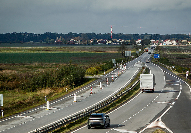 Na polích vlevo od silnice má vyrst satelitní sídlit. V pozadí je obec Dasný.