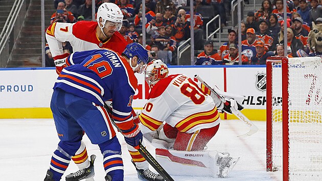 Branku Calgary st�e�� Daniel Vlada�, dotla�it puk do s�t� se pokou�� Zach Hyman z Edmontonu.