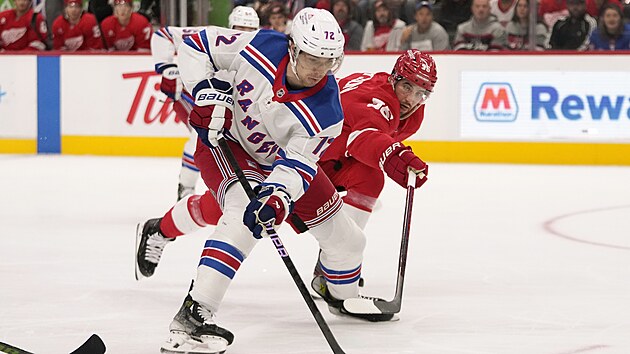 Filip Chytil z NY Rangers zkou�� udr�et puk, napad� ho Erik Gustafsson z Detroitu.