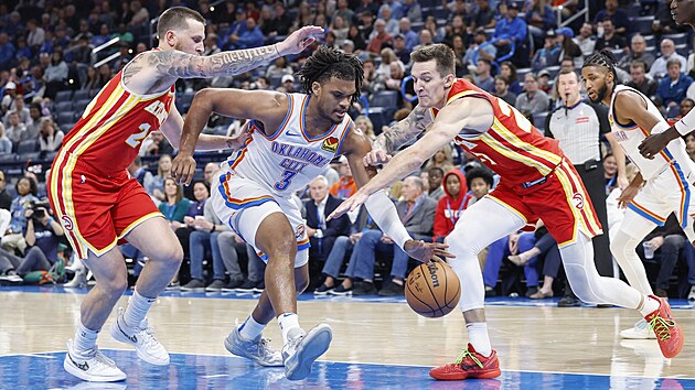 Dillon Jones z Oklahoma City se zkou dostat pes dvojici Garrison Mathews...