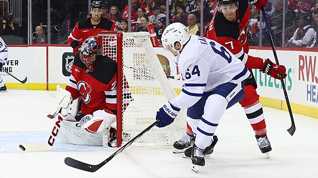 David K�mpf z Toronto Maple Leafs nahazuje puk p�ed brank��e Jacoba Markstr�ma z New Jersey,