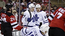 Bobby McMann a David Kämpf z Toronto Maple Leafs slaví gól proti New Jersey...