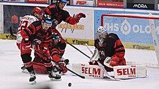 Olomoucký úto�ník Jan Ká�a (9) odpravuje puk od branky Mat�je Machovského p�i...