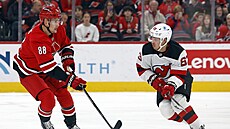 Úto�ník Caroliny Martin Ne�as (vlevo) posílá puk p�es obránce New Jersey...