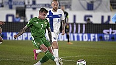 Irský fotbalista Sammie Szmodics (vlevo) st�ílí na finskou bránu, sleduje ho...