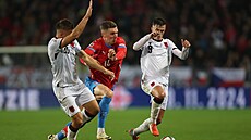 Luká� Provod se sna�í projít okolo dvou albánských hrá��.