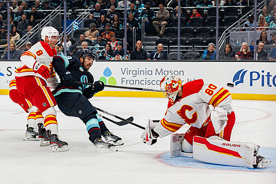 Branká� Dan Vlada� z Calgary Flames zasahuje b�hem zápasu se Seattle Kraken.