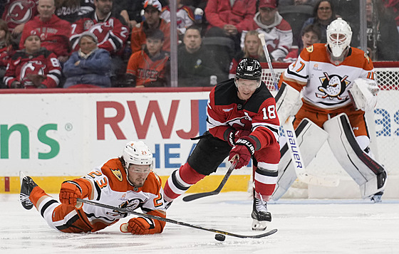 Mason McTavish (vlevo) z Anaheim Ducks odehrává puk, na který se snaí...