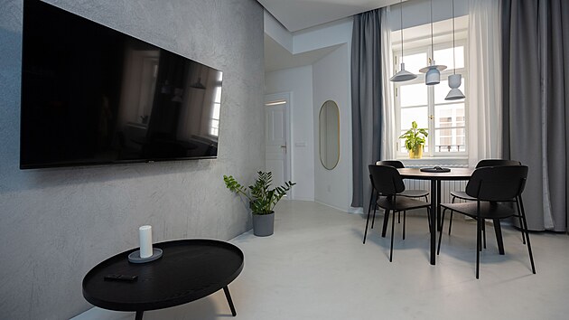 V ob�vac�m pokoji vis� ob�� televize a stoj� mal� j�deln� stolek.