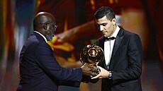 George Weah p�edává Zlatý mí� Rodrimu.