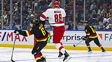 Martin Neas z Carolina Hurricanes v souboji s Brockem Boeserem z Vancouver...