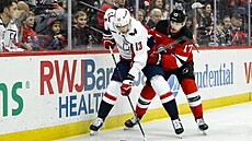 Jakub Vrána z Washington Capitals si kryje puk v utkání s New Jersey Devils...