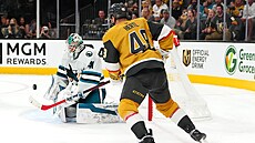 Útoník Vegas Tomá Hertl sleduje, jak branká San Jose Vítek Vanek kryje puk.