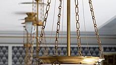 Secesní záv�sné lampy se zlacenými detaily osv�tlují aulu. Zdobí je tenké...