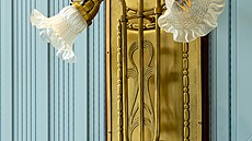 Lampy. Zlaté kv�tiny vyr�stají ze st�n auly a v pozdním odpoledni ji osv�tlují...