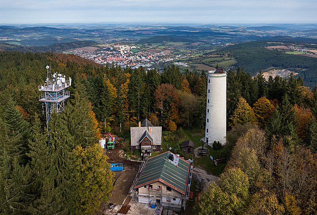 Opravovaná chata stojí hned u rozhledny. V pozadí jsou vidt Prachatice.