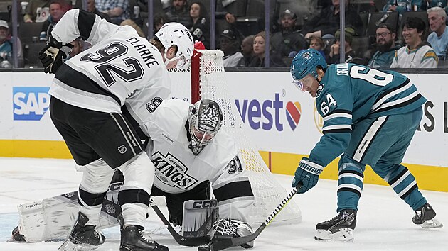 Brank David Rittich z Los Angeles zasahuje ped dotrajcm Mikaelem Granlundem ze San Jose. Pomh mu Brandt Clarke.