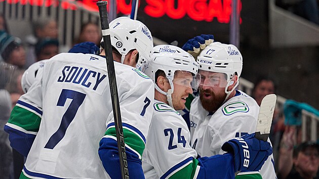 Filip Hronek (vlevo), Pius Suter a Carson Soucy z Vancouver Canucks slav� g�l proti San Jose Sharks.