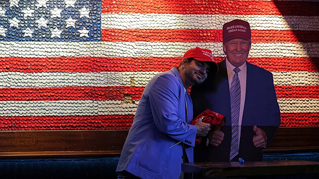 P��znivec republik�nsk�ho kandid�ta Donalda Trumpa obj�m� jeho kartonovou fotografii. (6. listopadu 2024)
